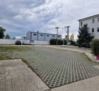 Parkplatz in der Šamorínska-Straße bei Lagerhäusern und Hallen, mit Kennzeichnung des Immobilienbüros.