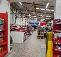 Der Laden in der Šamorínska-Straße bietet verschiedene Waren zwischen Lagern und Hallen an, aufgehängte Fahnen.