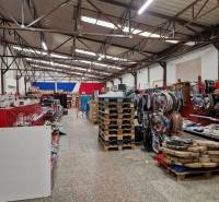 Lagerhäuser und Hallen in der Šamorínska-Straße, voll mit gelagerten Waren und Paletten.