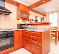 Küche in einer 2-Zimmer-Wohnung mit Holzküche, Herd, Dunstabzugshaube und Essecke.