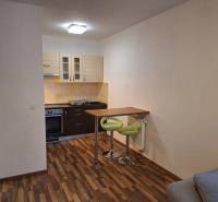 Küchenzeile mit Bartresen und Holzboden in einer 2-Zimmer-Wohnung.