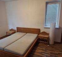 Schlafzimmer in einer 2-Zimmer-Wohnung mit einem Holzbett und Nachttischen.