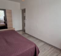 Schlafzimmer mit Bett, weißen Wänden und Schrank, 3-Zimmer-Wohnung.