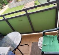 Balkon einer 3-Zimmer-Wohnung mit einem Plastikstuhl und einem kleinen Glastisch.