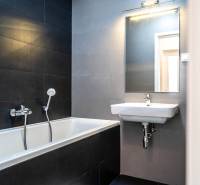 Badezimmer mit Dusche und Waschbecken in einer 2-Zimmer-Wohnung.