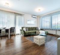Wohnzimmer in einer 2-Zimmer-Wohnung mit Holzboden, Sofa und Esstisch.