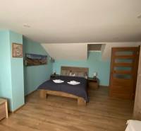 Schlafzimmer im Einfamilienhaus mit Ehebett, Holzboden und Dekorationen.