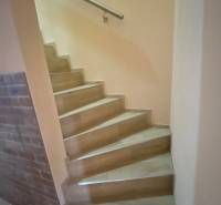 Treppe in einem Einfamilienhaus mit Ziegelwand und Stahlgeländer.