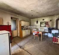 Eine Küche in einem Einfamilienhaus mit ländlichem Flair, enthält einen Herd und einen Esstisch.