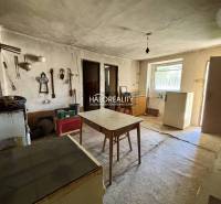 Interieur eines Einfamilienhauses mit Tisch, Kühlschrank und Werkzeugen an der Wand.