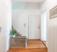 Flur mit Holzboden, Treppe, Bild und Heizkörper in einer 2-Zimmer-Wohnung.
