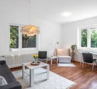 Helles Wohnzimmer in einer 2-Zimmer-Wohnung mit Sofa, Tisch und Schreibtisch.