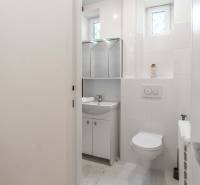 Badezimmer mit Toilette, Waschbecken und Spiegel in einer 2-Zimmer-Wohnung.