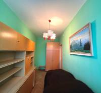 Ein schmales Zimmer in einer 3-Zimmer-Wohnung mit hellen Möbeln und einem Gemälde an der Wand.
