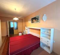 Schlafzimmer in einer 3-Zimmer-Wohnung mit Doppelbett, Schrank und Wanddekorationen.