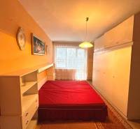Schlafzimmer mit Einbauschränken, Bett mit roter Decke in einer 3-Zimmer-Wohnung.