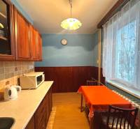 Küche in einer 3-Zimmer-Wohnung mit Holzmöbeln und Esstisch.