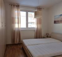 Schlafzimmer mit zwei Betten, Einbauschrank und Bild in einer Zweizimmerwohnung.