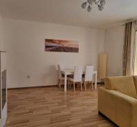 Wohnzimmer mit Esstisch und gelbem Sofa in einer Zweizimmerwohnung.