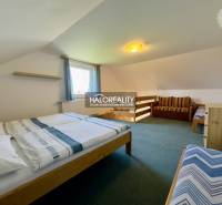 Schlafzimmer in einem Einfamilienhaus mit Betten, Sofa und Teppich.
