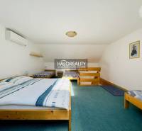 Ein Dachzimmer in einem Einfamilienhaus mit Klimaanlage und Holzbett.