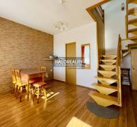 Innenraum eines Einfamilienhauses mit Holztreppe, Essecke und Holzboden.