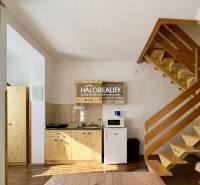 Holztreppe im Einfamilienhaus, kleine Küche mit Kühlschrank und Mikrowelle.