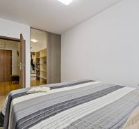 Schlafzimmer mit Bett, Buch, Plüschtier und Einbauschrank in einer 2-Zimmer-Wohnung.