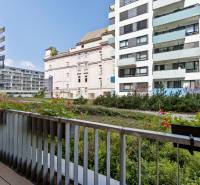 Blick vom Balkon mit Blumen auf die Gebäude in der Jégého-Straße in Bratislava.