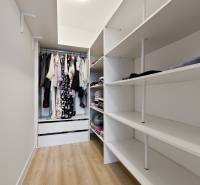 Ein Kleiderschrank in einer 2-Zimmer-Wohnung mit Regalen und einem Hängeplatz für Kleidung.