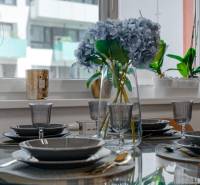 Ein elegant gedeckter Tisch mit Blumen in einer 2-Zimmer-Wohnung, Glasgeschirr und Besteck.