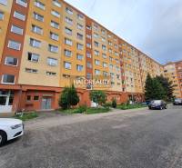Ein Wohnblock mit 3-Zimmer-Wohnungen in Prievidza, umgeben von Grünflächen und einem Parkplatz.
