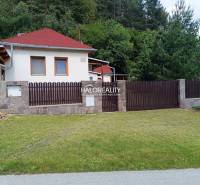 Ein Ferienhaus in Helcmanovce mit einem Holzzaun und gepflegtem Rasen, umgeben von Grün.