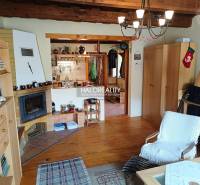 Das Innere der Hütte mit Kamin, Holzbalkendecke, gemütlichen Accessoires und bequemen Möbeln.