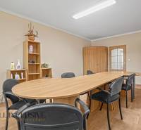 Besprechungsraum: Holztisch, Stühle, Schränke und Regale im Büro.