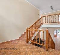 Innenraum eines Büros mit einer Holztreppe und Fliesenboden.