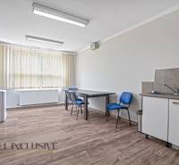 Büroausstattung: Schreibtisch, Stühle, Waschbecken, Wasserhahn und Jalousien.