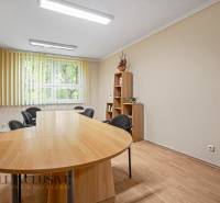 Esstisch mit Bücherregal und Bürostühlen im Büro.