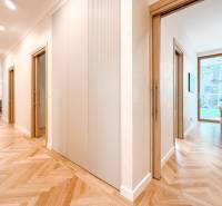 Der Flur in der 4-Zimmer-Wohnung mit Holzboden und Blick in das Zimmer.