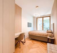 Schlafzimmer mit Tisch und Stuhl in einer 4-Zimmer-Wohnung, mit großem Fenster und Holzboden.