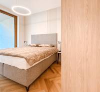 Schlafzimmer mit grauem Bett, Einbauschrank, Parkettboden und Ausblick in einer 4-Zimmer-Wohnung.