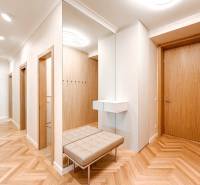 Geräumiger Flur mit Spiegel und Bank in einer 4-Zimmer-Wohnung mit Holztüren.