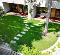 Gartenterrasse einer 4-Zimmer-Wohnung mit Rasen und Holzmöbeln.