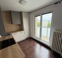Küche in einer 2-Zimmer-Wohnung mit einer Holzarbeitsplatte und Zugang zum Balkon.