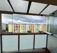 Ein verglaster Balkon mit Blick auf die bunten Wohnblöcke in Nová Dubnica in der SNP-Straße.