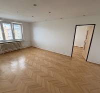 Ein Zimmer mit Parkettboden, weißen Wänden und Fenstern, Teil einer 2-Zimmer-Wohnung.