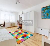 Kinderzimmer in einer 3-Zimmer-Wohnung mit einem bunten Teppich und einem Schreibtisch.