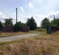 Grundstück - Gewerbe in Trenčianske Bohuslavice mit alten Zäunen und einer kaputten Straße.
