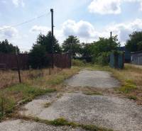 Der befestigte Weg führt durch Grundstücke - kommerziell in Trenčianske Bohuslavice, umgeben von Grün.