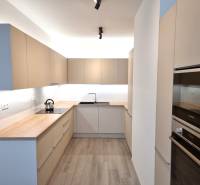 Küche mit einer Arbeitsplatte aus Holz und eingebauten Geräten in einer 3-Zimmer-Wohnung.